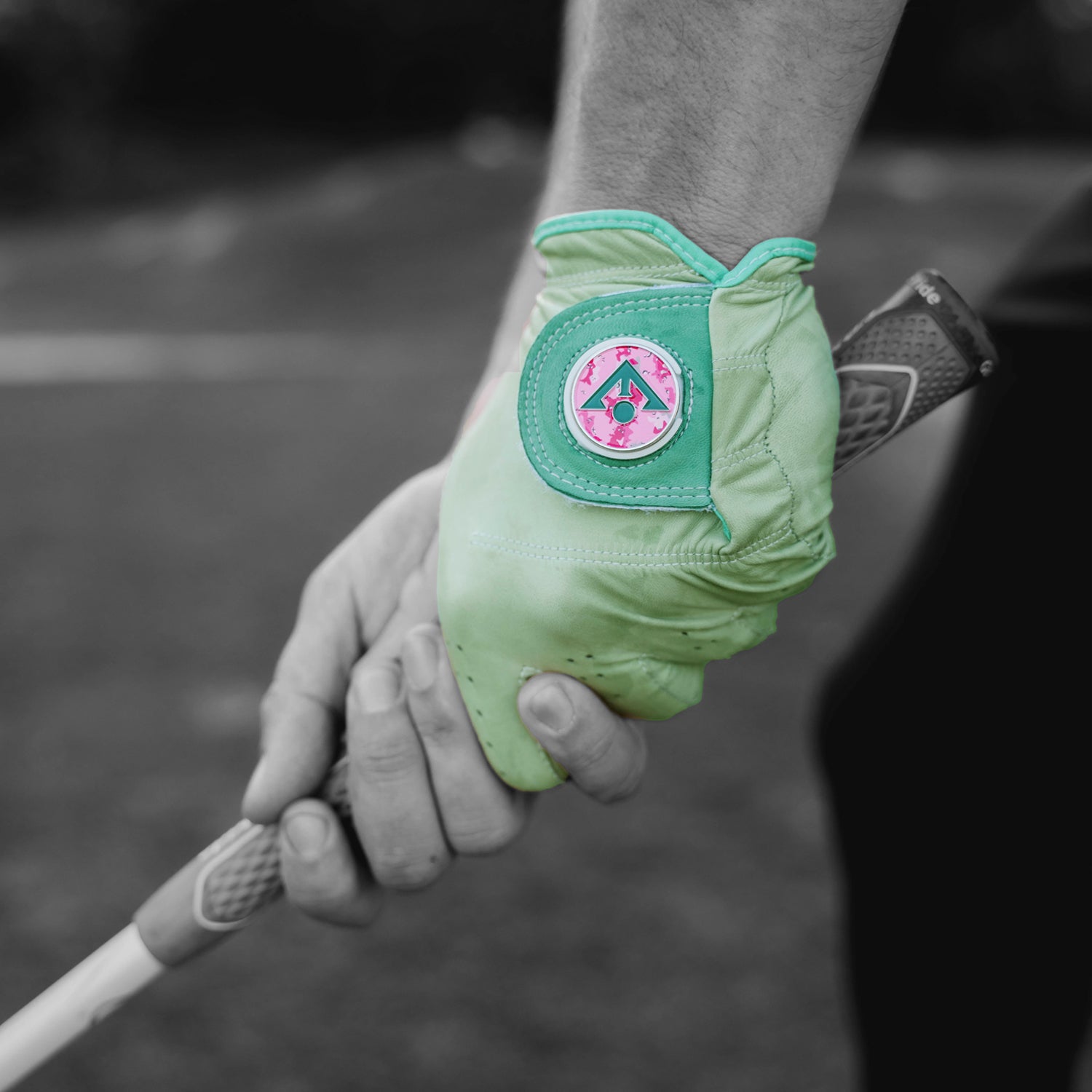 Men's colored golf glove in a seafoam green with a pink magnetic ball marker up close and in black and white background.