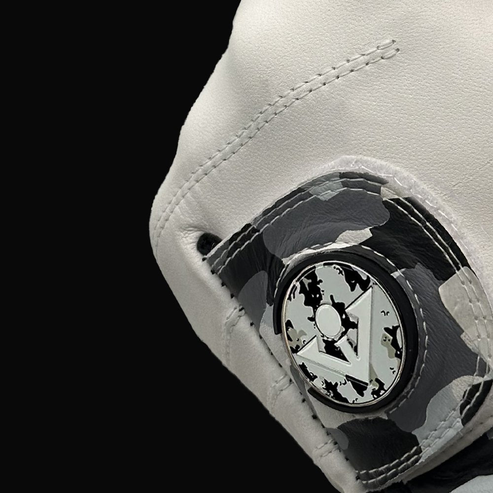 Camo pull tab on golf glove with magnetic ball marker, close up showing the ball marker in the cavity.