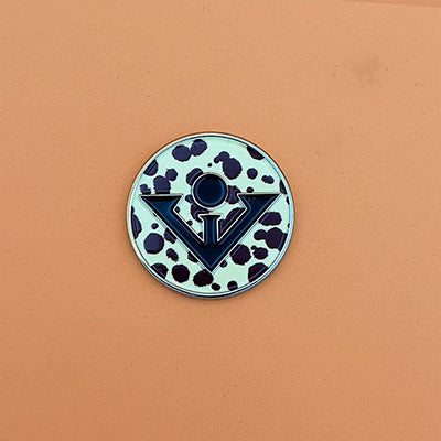 Printed magnetic golf ball marker with cheetah design on an orange backdrop.