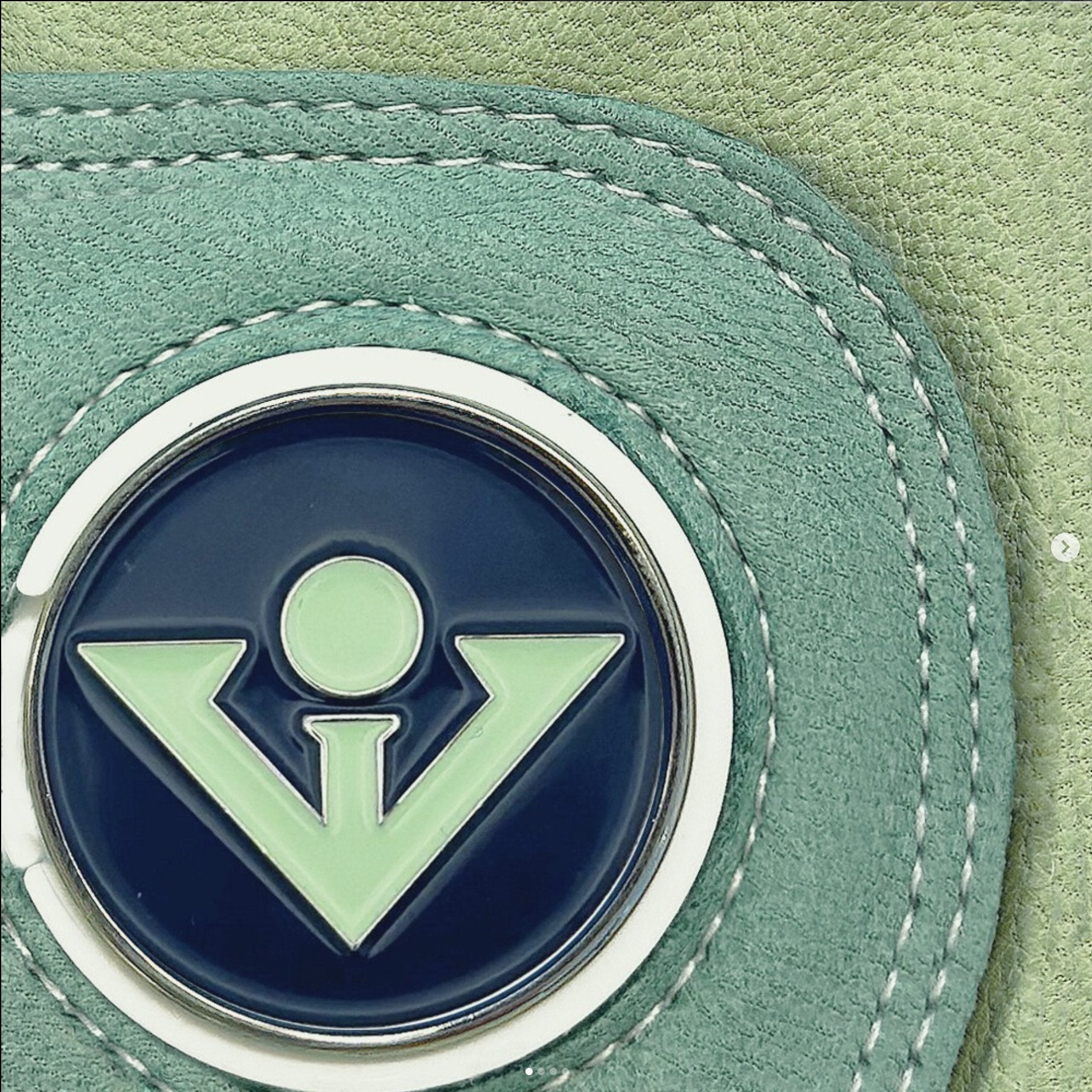 Close up of a VivanTee unique golf glove with magnetic ball marker in green and blue.