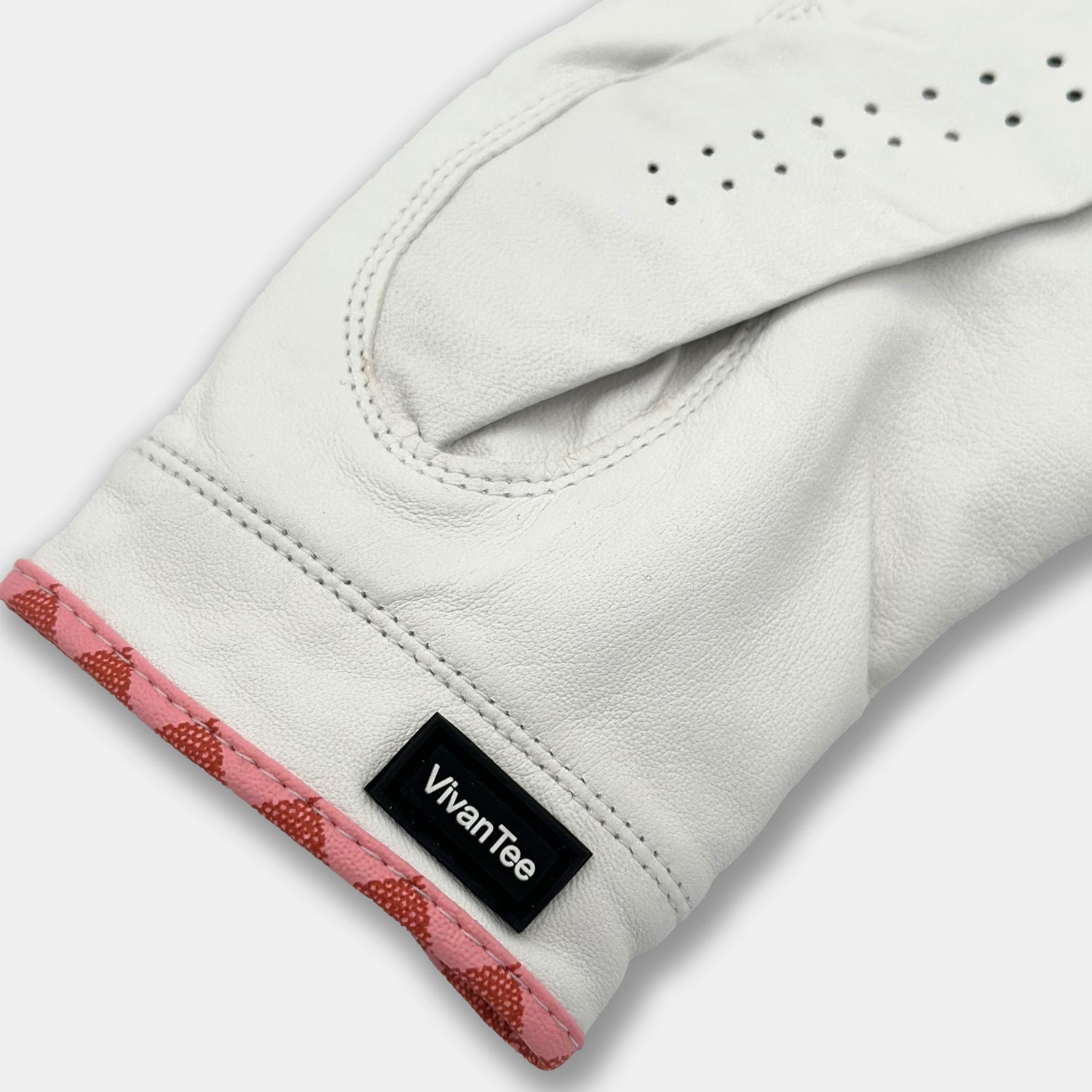 Golf glove with pink piping and "VivanTee" tag.